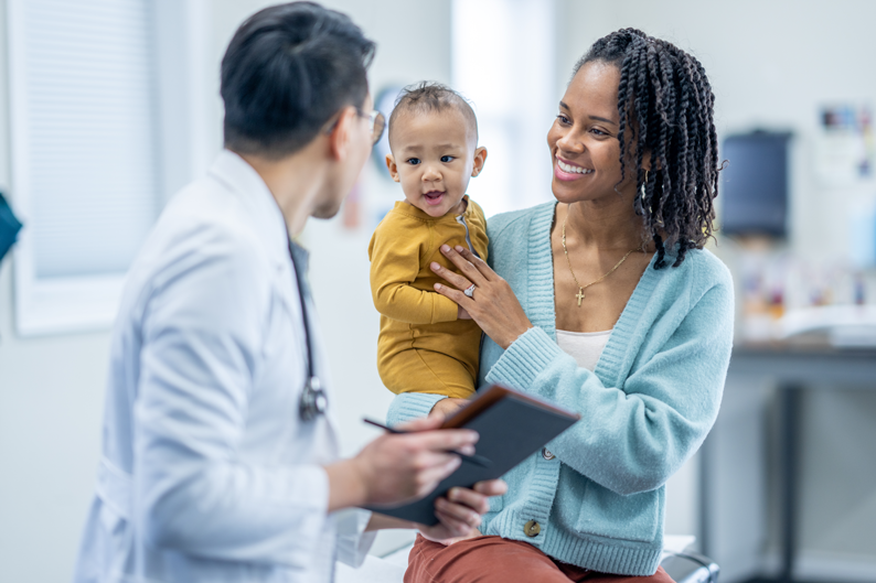 Mother holds baby during doctors consultation