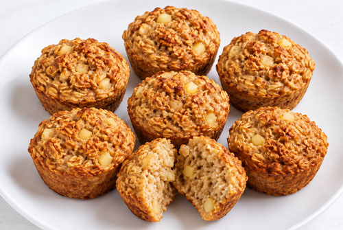 Plate of apple cinnamon oat muffins, one cut open