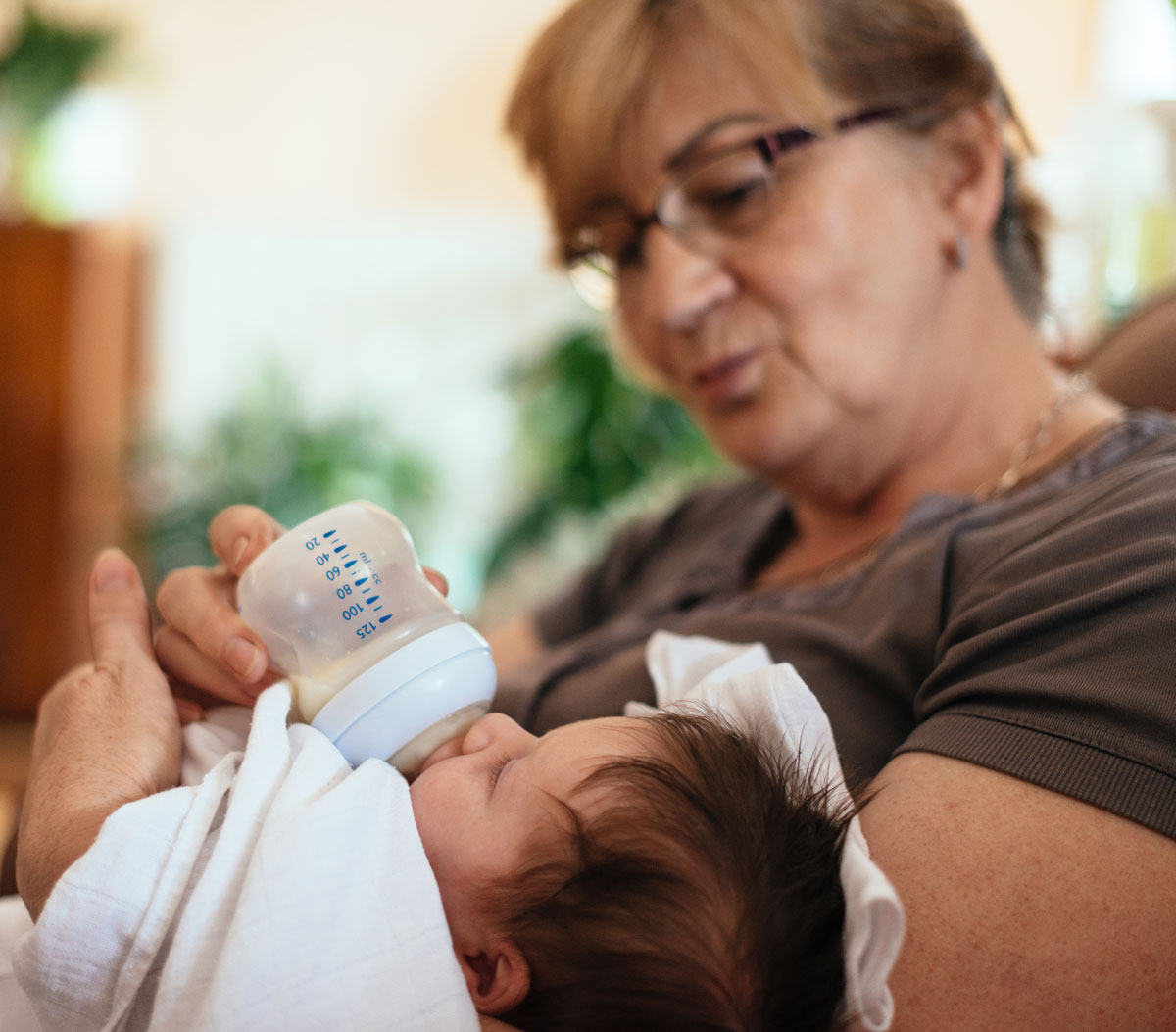 Woman bottle-feeding a baby in her arms