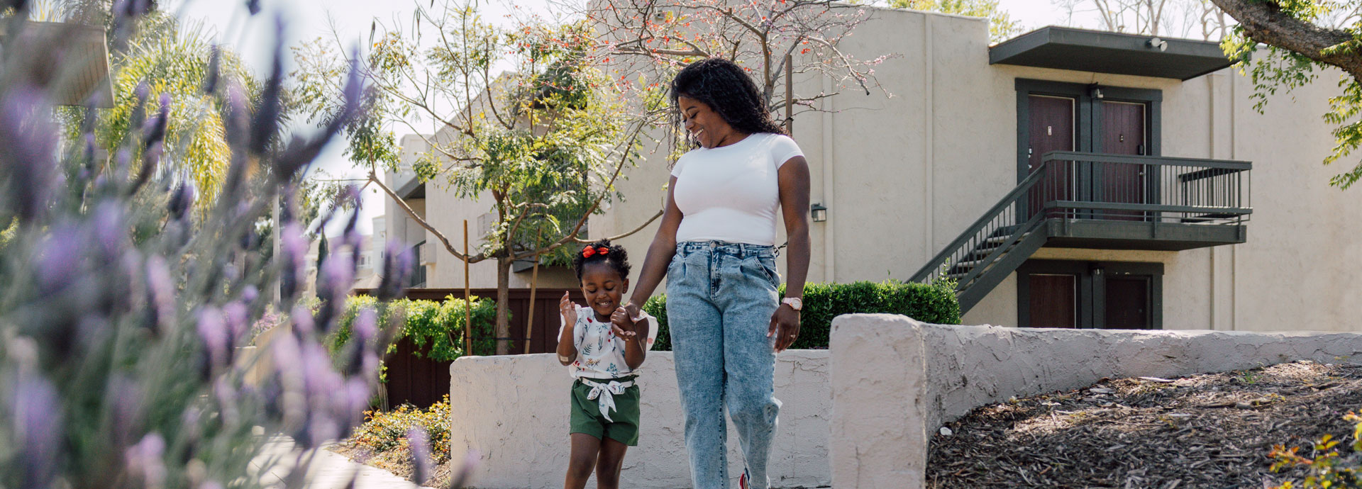 Woman walking with child outside, holding hands