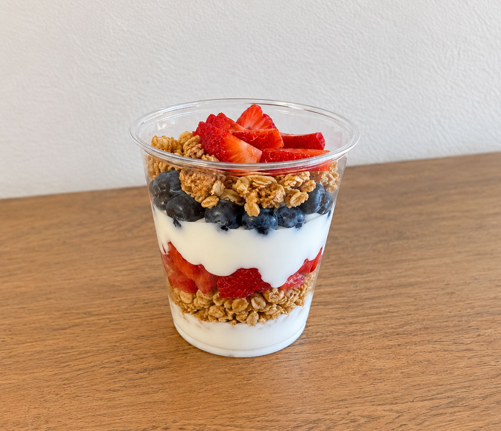 Yogurt parfait layered with granola, strawberries, and blueberries