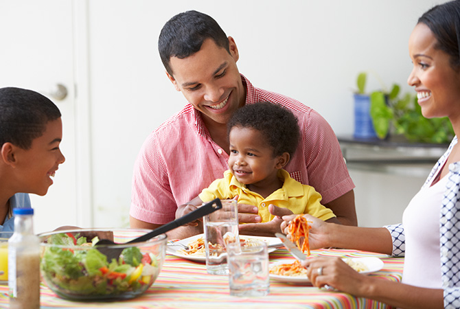 Family enjoying meal together at a colorful table.