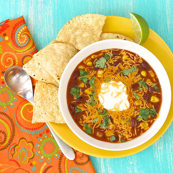 Soup with toppings, served with chips and lime