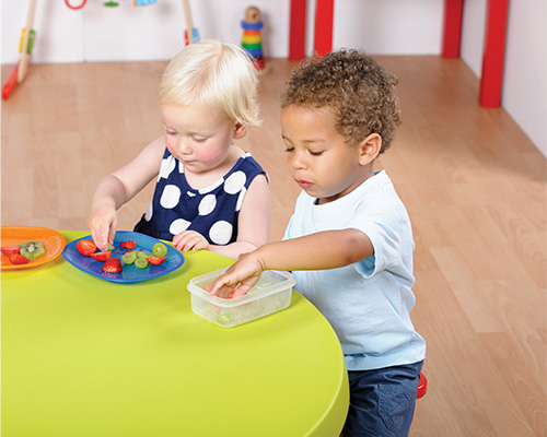 Children eating fruit at a table together