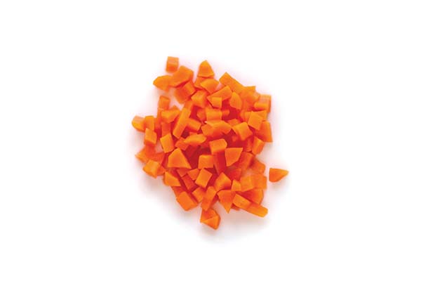 Chopped carrots scattered on a white background