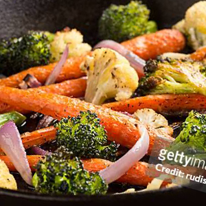 Roasted vegetables in a pan, including carrots and broccoli