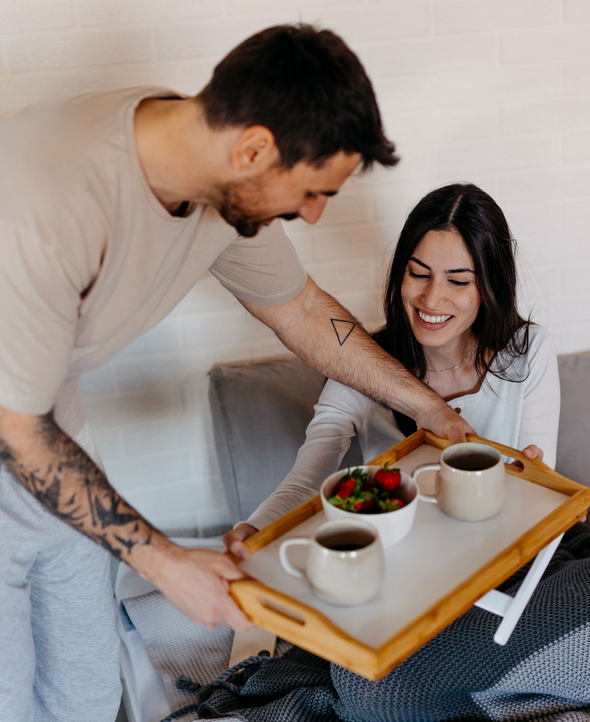 Man bringing woman breakfast in bed