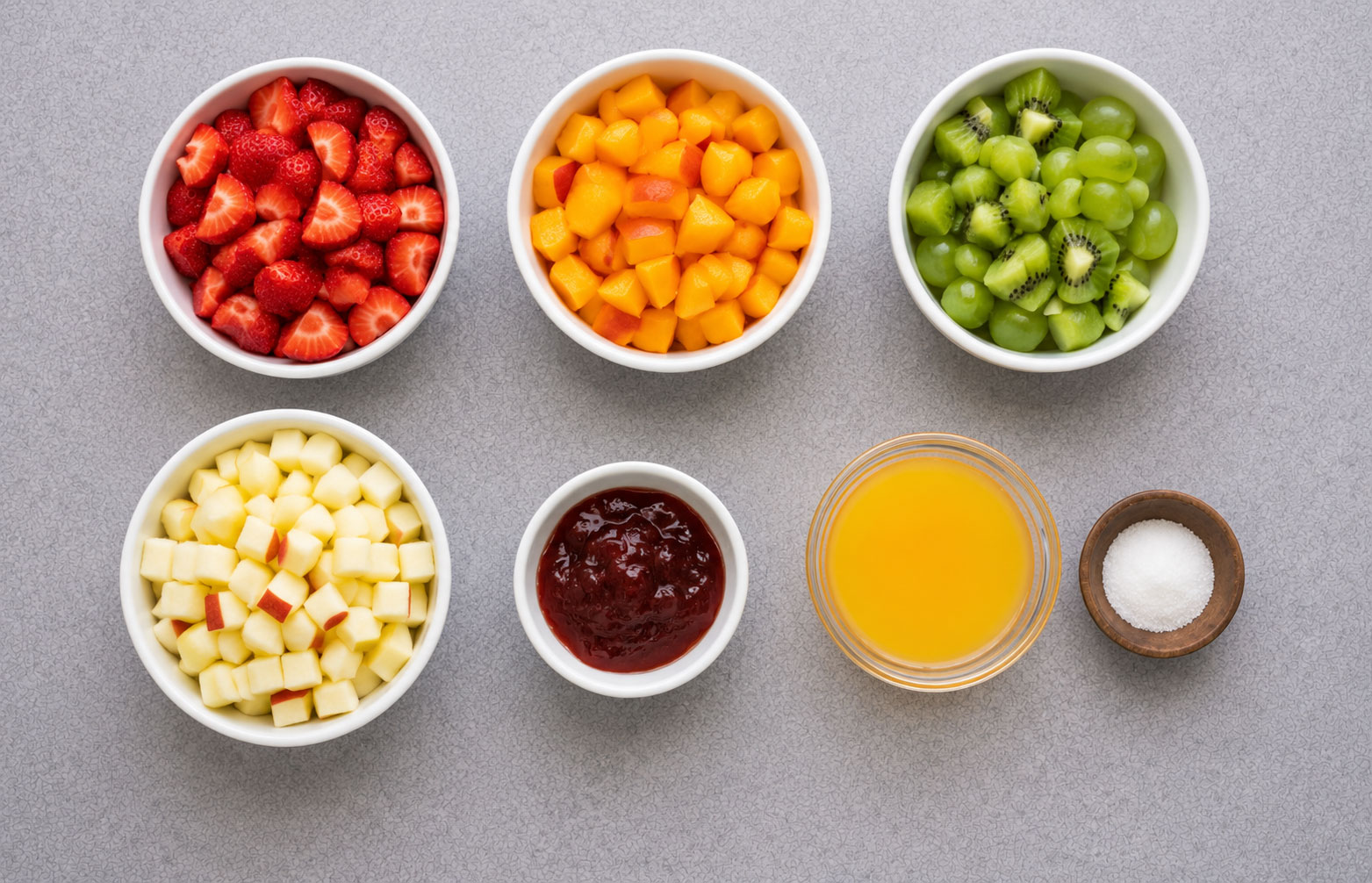 Bowls of chopped fruit and juice arranged neatly