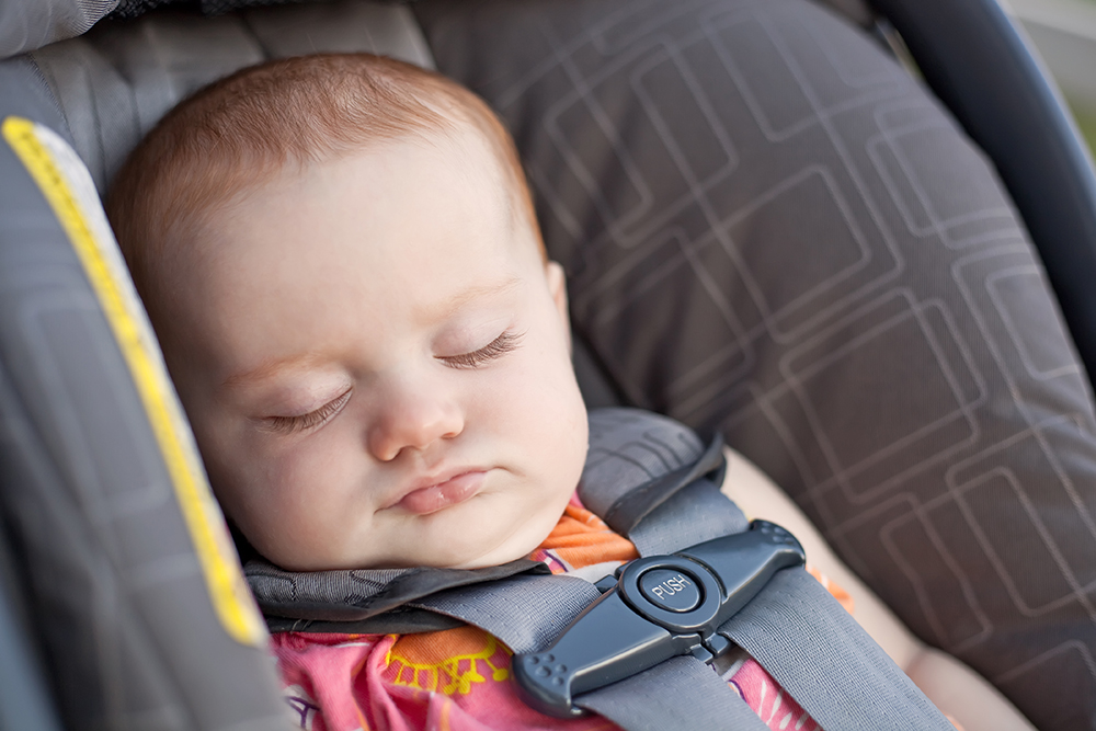Baby secured in rear-facing car seat